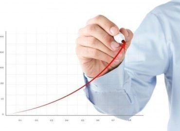 A person in business attire drawing an upward trend line on a graph depicting exponential growth, isolated on a white background.