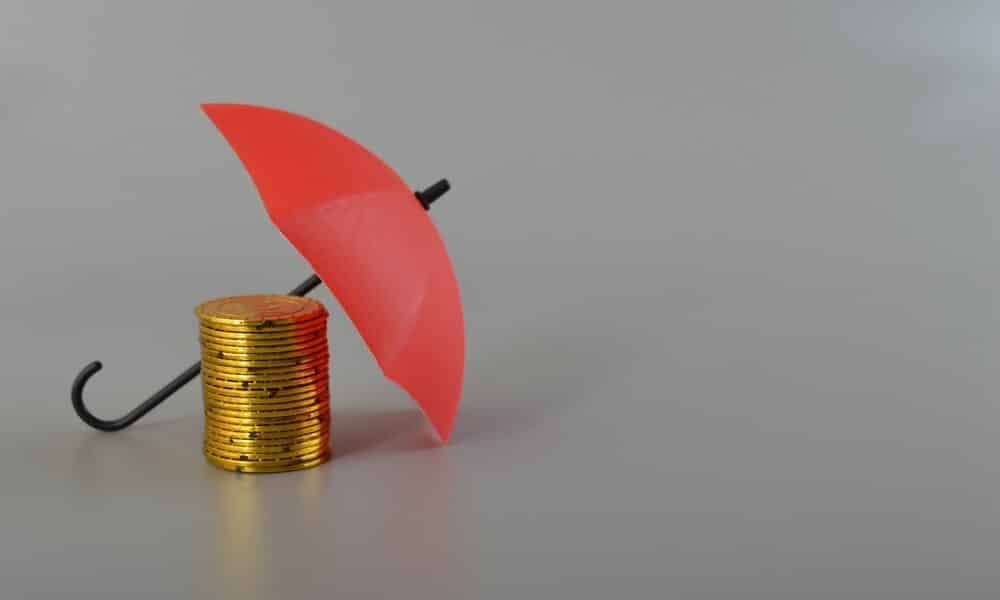 Red umbrella and the stack of coins. Keeping money safe. savings protection, Investment and capital insurance concept.