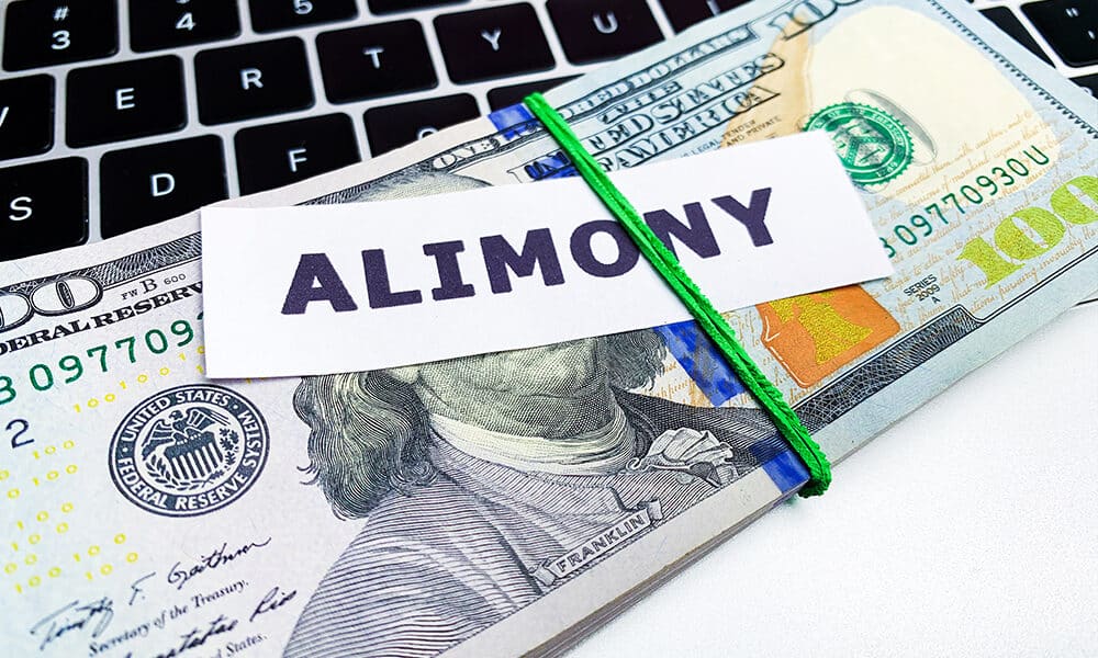 Concept of paying alimony, stack of money on the table.