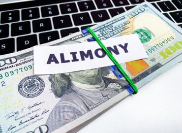 Concept of paying alimony, stack of money on the table.