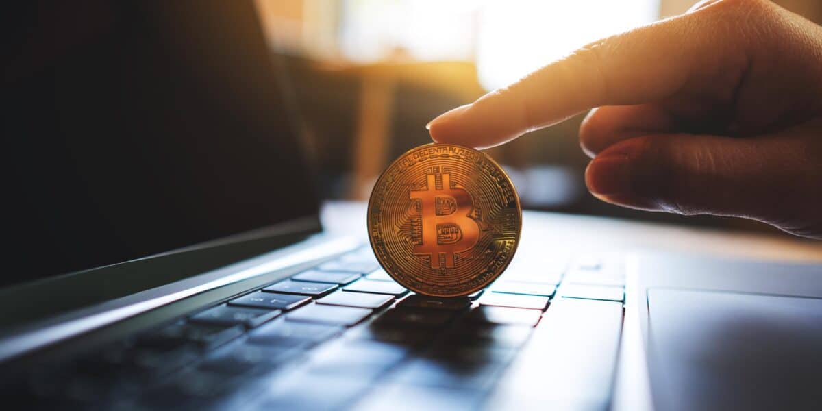 People holding and showing bitcoin on laptop computer