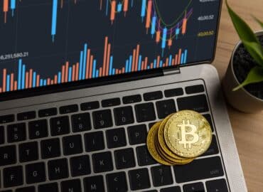 Close up bitcoin on laptop on table at home, cryptocurrency profit and income from investing in stock to exchange crypto and pay to buy in financial technology market investor in e-commerce concept